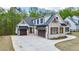Beautifully designed home with stone, wood, and white siding, complimented with a driveway at 71 Ramey Rd, Sugar Hill, GA 30518