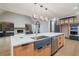 Gourmet kitchen with a large island featuring a stainless steel sink, dishwasher, and modern appliances at 71 Ramey Rd, Sugar Hill, GA 30518