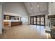 Open-concept living room with gourmet kitchen, stone fireplace, and folding patio doors to a scenic outdoor space at 71 Ramey Rd, Sugar Hill, GA 30518