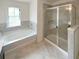 Bright bathroom with soaking tub, stand up shower and tiled floors at 7526 Stone Creek Path, Lithonia, GA 30038