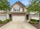 Charming townhome featuring a two-car garage, stone accents, and neutral siding at 7526 Stone Creek Path, Lithonia, GA 30038