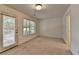 Bright bedroom featuring carpet flooring, two windows and a door at 10898 Gallier St, Johns Creek, GA 30022