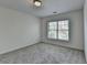 Neutral bedroom featuring carpet flooring and a window bringing in natural light at 10898 Gallier St, Johns Creek, GA 30022