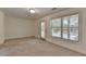 Bright bedroom featuring carpet flooring, two windows and a door at 10898 Gallier St, Johns Creek, GA 30022