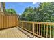 A wooden deck with privacy lattice offers a comfortable outdoor space, surrounded by lush green trees at 10898 Gallier St, Johns Creek, GA 30022