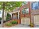Charming brick townhome featuring an attached garage, a welcoming front porch and professional landscaping at 10898 Gallier St, Johns Creek, GA 30022