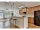 Modern kitchen with a breakfast bar, stainless steel appliances, and seamless flow into the living area at 10898 Gallier St, Johns Creek, GA 30022