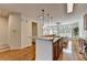 Open-concept kitchen showcasing stainless steel appliances, a breakfast bar, and hardwood floors at 10898 Gallier St, Johns Creek, GA 30022