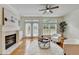 Bright living room featuring a fireplace, hardwood floors, modern décor, and doors leading to a deck at 10898 Gallier St, Johns Creek, GA 30022