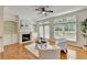 Bright living room featuring a fireplace, hardwood floors, modern décor, and doors leading to a deck at 10898 Gallier St, Johns Creek, GA 30022