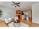 Cozy living space with a modern ceiling fan, hardwood floors, and an open layout to the adjacent kitchen at 10898 Gallier St, Johns Creek, GA 30022