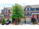 Exterior facade of brick townhomes features garages, stairs, and colorful front doors at 10898 Gallier St, Johns Creek, GA 30022