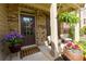 Inviting front porch with brick, flowers, seating, and a hanging fern, perfect for relaxing at 2906 Ansley Manor Ct, Marietta, GA 30062