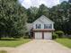 Charming two-story home featuring a well-manicured lawn, mature trees, and an attached two-car garage at 3416 N Cook Rd, Powder Springs, GA 30127
