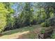 Lush backyard featuring large trees, a grassy lawn, and a wooden bench at 825 Loridans Ne Cir, Atlanta, GA 30342
