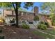 Exterior rear of home showcasing brick facade, deck with access to backyard, and beautiful landscaping at 825 Loridans Ne Cir, Atlanta, GA 30342