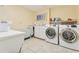 Bright laundry room with white washer and dryer, a sink, and ample storage space at 825 Loridans Ne Cir, Atlanta, GA 30342