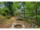 Wooded backyard with stone firepit and picnic table at 832 Wyntuck Nw Dr, Kennesaw, GA 30152