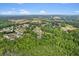 Wide aerial view of a residential area surrounded by lush greenery and a partial view of a lake at 109 J O Simmons Path, Douglasville, GA 30134