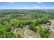 Aerial view of the property surrounded by dense trees, homes, and a nearby lake, emphasizing its serene location at 109 J O Simmons Path, Douglasville, GA 30134