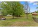 Expansive fenced backyard with mature trees and a storage shed, offering ample space for outdoor activities at 109 J O Simmons Path, Douglasville, GA 30134