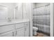 Clean bathroom showcasing a single sink vanity, large mirror, and a shower with patterned curtain at 2292 W Village Junction Se Way, Smyrna, GA 30080
