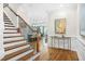 Elegant foyer features a staircase, hardwood floors, decorative console table, and views of the kitchen at 2292 W Village Junction Se Way, Smyrna, GA 30080