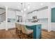 Modern kitchen features white cabinets, a teal island with seating, stainless steel appliances, and beautiful pendant lighting at 2292 W Village Junction Se Way, Smyrna, GA 30080