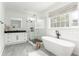Large bathroom with free-standing tub, glass shower, black hardware, and white subway tile at 425 Harold Ne Ave, Atlanta, GA 30307