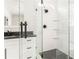 Bathroom featuring glass shower with black hardware, white tile, and black granite countertop at 425 Harold Ne Ave, Atlanta, GA 30307