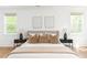 Stylishly staged bedroom featuring matching nightstands, hardwood floors, and large bright windows at 425 Harold Ne Ave, Atlanta, GA 30307