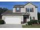 Two-story home features a two car garage, neutral siding, and a welcoming entrance at 6069 Semaphore Rdg, Rex, GA 30273