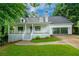 Charming home featuring a welcoming front porch, lush green lawn, and beautiful landscaping at 1007 Natalie Se Ln, Smyrna, GA 30082
