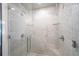 Modern walk-in shower featuring white marble tiling, glass door, dual showerheads, and corner shelves at 1007 Natalie Se Ln, Smyrna, GA 30082