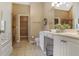 Bright bathroom with double sinks, tile floor, and a walk-in closet at 1593 Fredricksberg Dr, Loganville, GA 30052