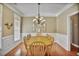 Formal dining room with a large table, chandelier, and beautiful hardwood floors and trim at 1593 Fredricksberg Dr, Loganville, GA 30052