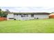 Exterior view of the backyard featuring a lush lawn, white brick house, and wooden fence at 2103 Blue Creek Ct, Conley, GA 30288