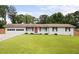 Charming ranch-style home featuring a well-manicured lawn, double garage, and a striking red front door at 2103 Blue Creek Ct, Conley, GA 30288