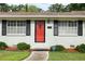 Up-close view of home entrance with red door, black shutters, manicured bushes, and clear house number at 2103 Blue Creek Ct, Conley, GA 30288