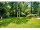 Expansive backyard featuring lush lawn, mature trees, playset, and partial view of the in-ground pool at 2910 Edwards Ct, Marietta, GA 30068