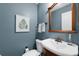 Stylish powder room with a pedestal sink, decorative mirror, and serene blue walls at 2910 Edwards Ct, Marietta, GA 30068