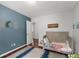 Bedroom featuring hard wood floors, natural light, crib, and blue accent wall at 2910 Edwards Ct, Marietta, GA 30068