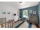 Bedroom with blue accent wall, crib, dresser, and decorative items at 2910 Edwards Ct, Marietta, GA 30068