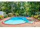 Backyard pool with deck, green surroundings, table and seating under umbrella at 2910 Edwards Ct, Marietta, GA 30068