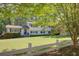 Two-story home with a lush green lawn, white fence, and mature trees creating a serene setting at 3519 Sunderland Ne Way, Brookhaven, GA 30319
