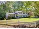 Charming two-story home with a lush green lawn, white fence, and mature trees creating a serene setting at 3519 Sunderland Ne Way, Brookhaven, GA 30319