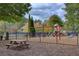 Fenced playground area with swings, slides, picnic table, and soft ground for safety at 3519 Sunderland Ne Way, Brookhaven, GA 30319