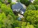 An aerial view shows a backyard with a putting green, a patio with seating and mature trees at 12815 Oak Falls Dr, Alpharetta, GA 30009