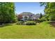 Beautiful backyard with a lush lawn, patio seating, mature trees, and ample space for outdoor activities and relaxation at 12815 Oak Falls Dr, Alpharetta, GA 30009