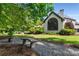 Secluded backyard with a view of a garden bench, mature trees, lush landscaping, and a patio with outdoor seating at 12815 Oak Falls Dr, Alpharetta, GA 30009